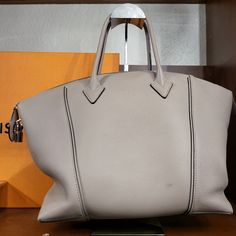 This Is An Authentic Louis Vuitton Veau Cachemire Soft Lockit Mm In Galet. This Stylish Tote Is Crafted Of Grained Cachemire Calfskin Leather In Grey-Beige. The Bag Features Rolled Leather Top Handles And A Removable, Adjustable Shoulder Strap With Silver Hardware. The Top Zipper Opens To A Suede Interior With Zipper And Patch Pockets. Luxury Gray Shoulder Bag With Top Carry Handle, Luxury Gray Bag With Top Carry Handle, Luxury Gray Bag With Palladium Hardware, Luxury Gray Satchel Bag, Luxury Gray Bag With Removable Pouch, Luxury Gray Top Handle Satchel, Designer Gray Bags, Luxury Gray Shoulder Bag With Dust Bag, Luxury Gray Shoulder Bag With Palladium Hardware