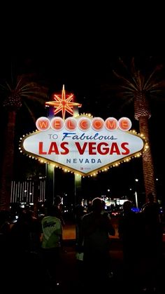 the welcome to fabulous las vegas sign lit up at night with palm trees in the background