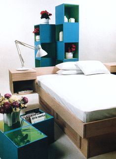 a bed sitting next to a table with flowers on it