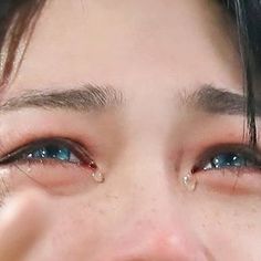 a close up of a person with tears on their eyes