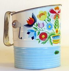 a blue and white can with flowers painted on it