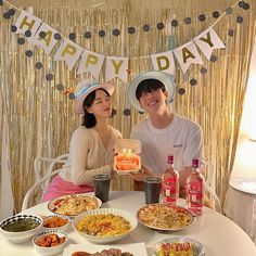 two people sitting at a table with plates of food