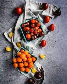 tomatoes and other fruits on a table with napkins next to them, including one tomato