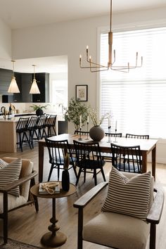 a living room filled with furniture next to a kitchen and dining room table in front of a window