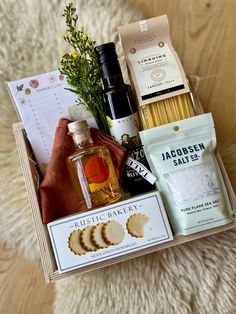 a wooden box with some food and drinks in it on a white carpeted surface