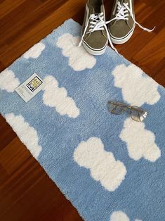 a pair of shoes sitting on top of a blue rug next to a pair of glasses