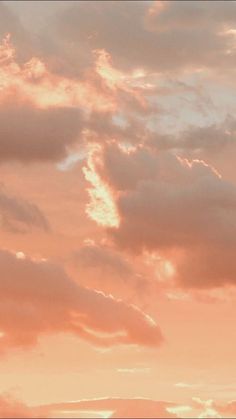 an airplane is flying in the sky at sunset or dawn with some clouds behind it