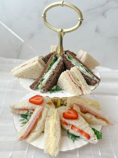 a three tiered plate with sandwiches on it