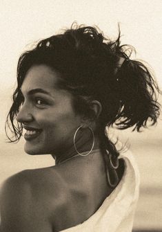 black and white photograph of a woman with her hair blowing in the wind, wearing large hoop earrings