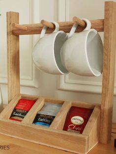 two mugs are hanging from a wooden rack with three cups on it's sides