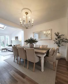 the dining room table is surrounded by beige chairs