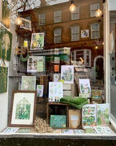 a store front window filled with lots of cards and pictures on display in the windows