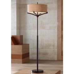 a lamp that is sitting on top of a wooden table in front of a wall