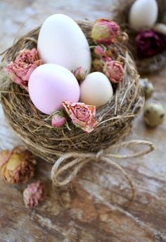 three eggs in a nest with pink flowers