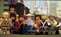 a group of lego people standing next to each other in front of a cityscape