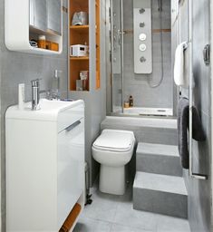 a small bathroom with a toilet, sink and shower stall in the middle of it