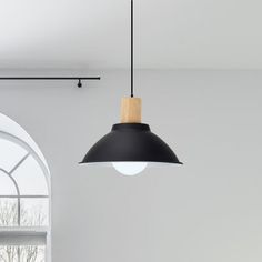 a black and white lamp hanging from a ceiling in a room with arched windows on both sides