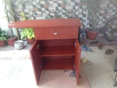 a wooden cabinet sitting on top of a tiled floor