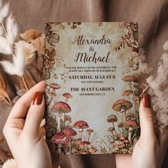 two hands holding up a wedding card with mushrooms on it and the words, alexandria & michael