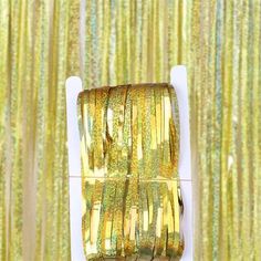 gold foiled ribbon on a white box with green and yellow stripes in the background