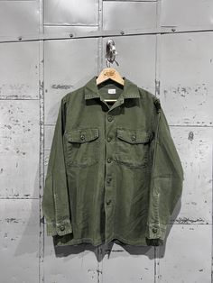 70's OG-107 Fatigue Button Up Shirt- Vietnam War(Army Green)  Great vintage condition. See pictures for condition 15.5x33 . Please review measurements as some vintage items fit smaller than modern sizing. Measurements taken with garment laid flat: 21" across from armpit to armpit 28" length from shoulder to hem 23" sleeve from shoulder to hem Please send a message if you have any questions. Double check measurements and inspect all pictures carefully before purchasing. Orders ship via USPS. All Green Military Style Button-up Shirt, Cotton Long Sleeve Camp Shirt With Button Closure, Green Military Button-up Top, Military Button-up Shirt, Military Style Button-up Tops, Military Style Button-up Shirt With Pockets, Military Style Button-up Tops With Snap Buttons, Green Button-up Camp Shirt With Pockets, Military Style Shirt With Button Closure For Fall