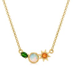 a gold necklace with an opal and star charm on the front, sitting on a white background