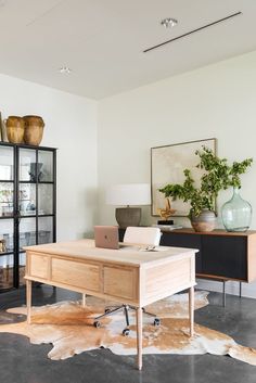 a living room filled with furniture and a wooden table in front of a glass case