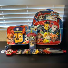 children's school supplies including backpack, toothbrush and pencil case on table with blinds in background