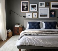 a bedroom with gray walls and pictures on the wall