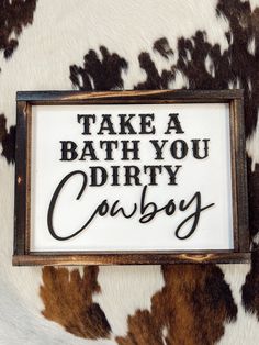 there is a sign that says take a bath you dirty cowboy on the cow skin