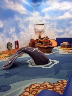 the room is decorated with blue and white walls, carpeted flooring, and an inflatable slide