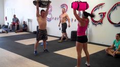 a group of people in a gym doing crossfit exercises with their hands up