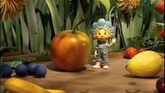 a cartoon character standing in front of an assortment of fruits and veggies on the ground