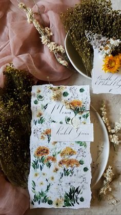 the table is set with flowers and place cards