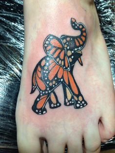 an orange and black elephant tattoo on the foot