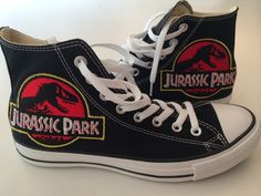 a pair of black high top sneakers with red and blue dinosaurs on the side,