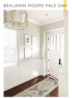 an entryway with white walls and wood floors