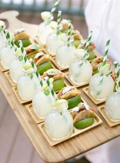 there are many appetizers on the tray with green and white striped straws