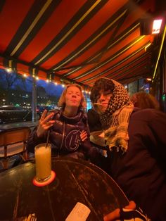 two women sitting at a table with drinks