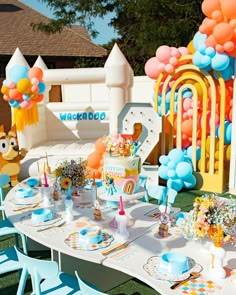 an outdoor birthday party with balloons and decorations