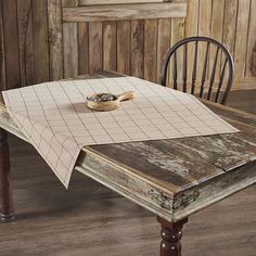 a wooden table with two chairs and a napkin on it that is sitting on top of the table