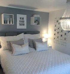 a bed with white and gray pillows in a bedroom