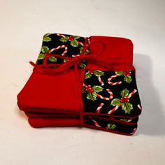 three pieces of cloth with holly and candy canes on them