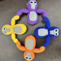 three stuffed monkeys sitting on top of each other in the shape of an oar