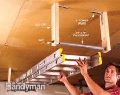 a man is working on the underside of a garage ceiling fixture with yellow tape around it