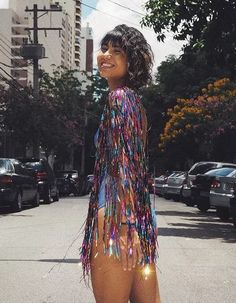 a woman in a colorful dress standing on the street