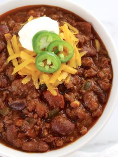 a white bowl filled with chili and cheese