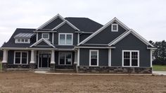 a large gray house with white trim and windows