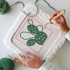 someone is working on a cross - stitch project with green yarn and crochet