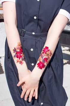 a woman with flowers painted on her arm and hand is holding onto the other arm